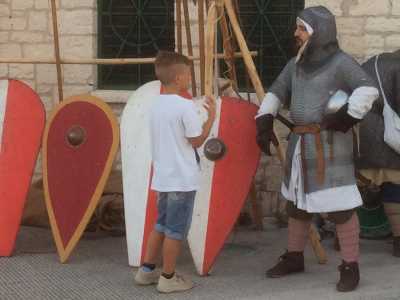 Un bambino, incuriosito dall'evento, chiede informazioni a un figurante della Compagnia d'arme Stratos